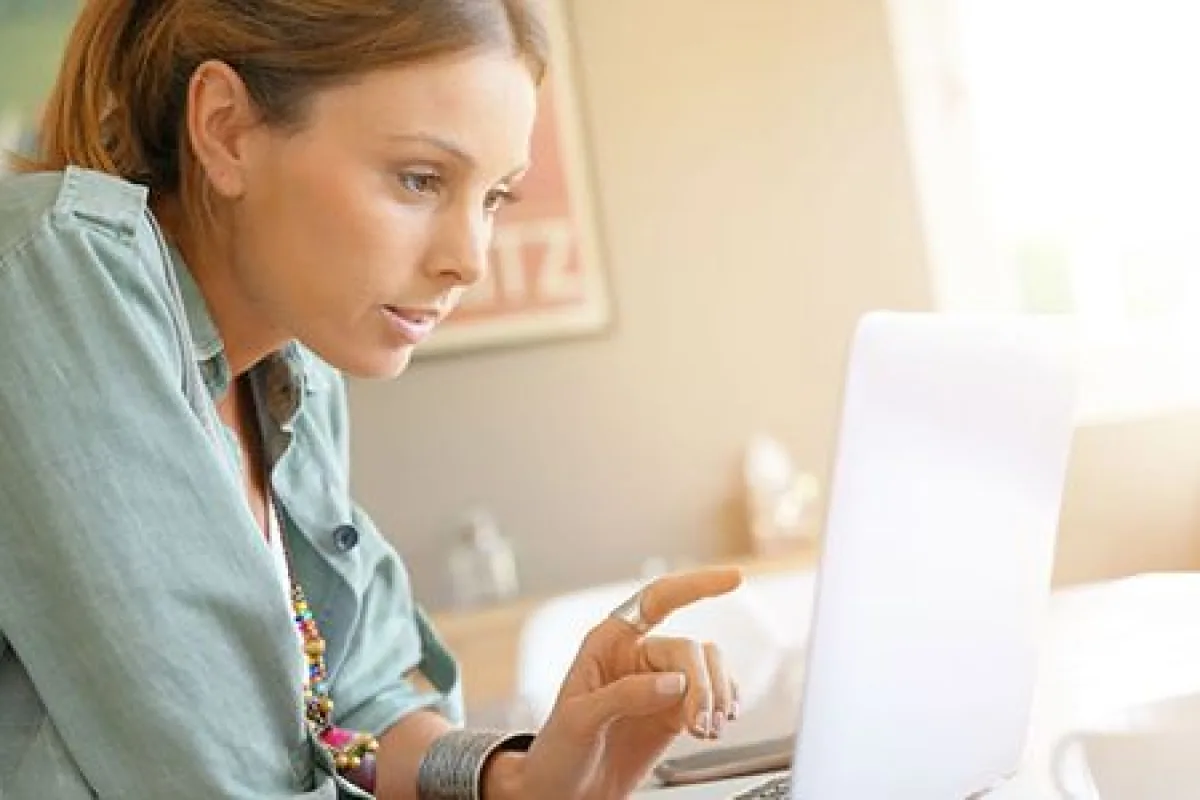 Une femme suit une séance de coaching en ligne sur son ordinateur portable