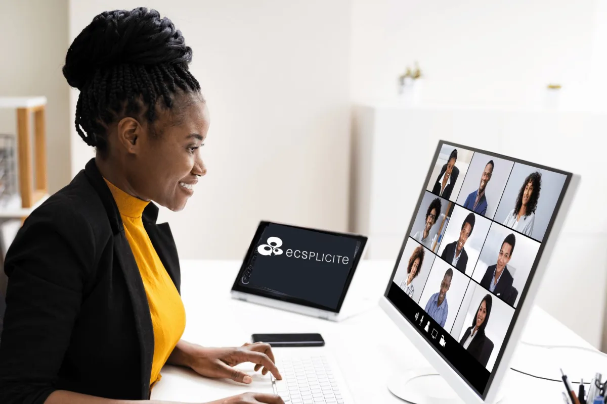 Une professionnelle échange en visio avec une dizaine de participants affichés à l’écran